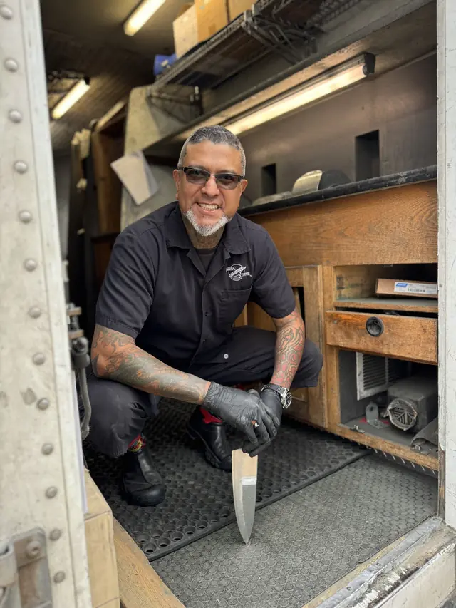 Joey, a Rolling Sharpening Stone sharpener, inside the sharpening truck